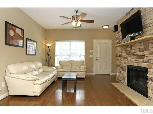 8015 Fanleaf Trail Raleigh, NC 27612 - Photo 4 of 23 Another view of the living room with floor to ceiling stone gas log fire place with cement mantle and hearth.