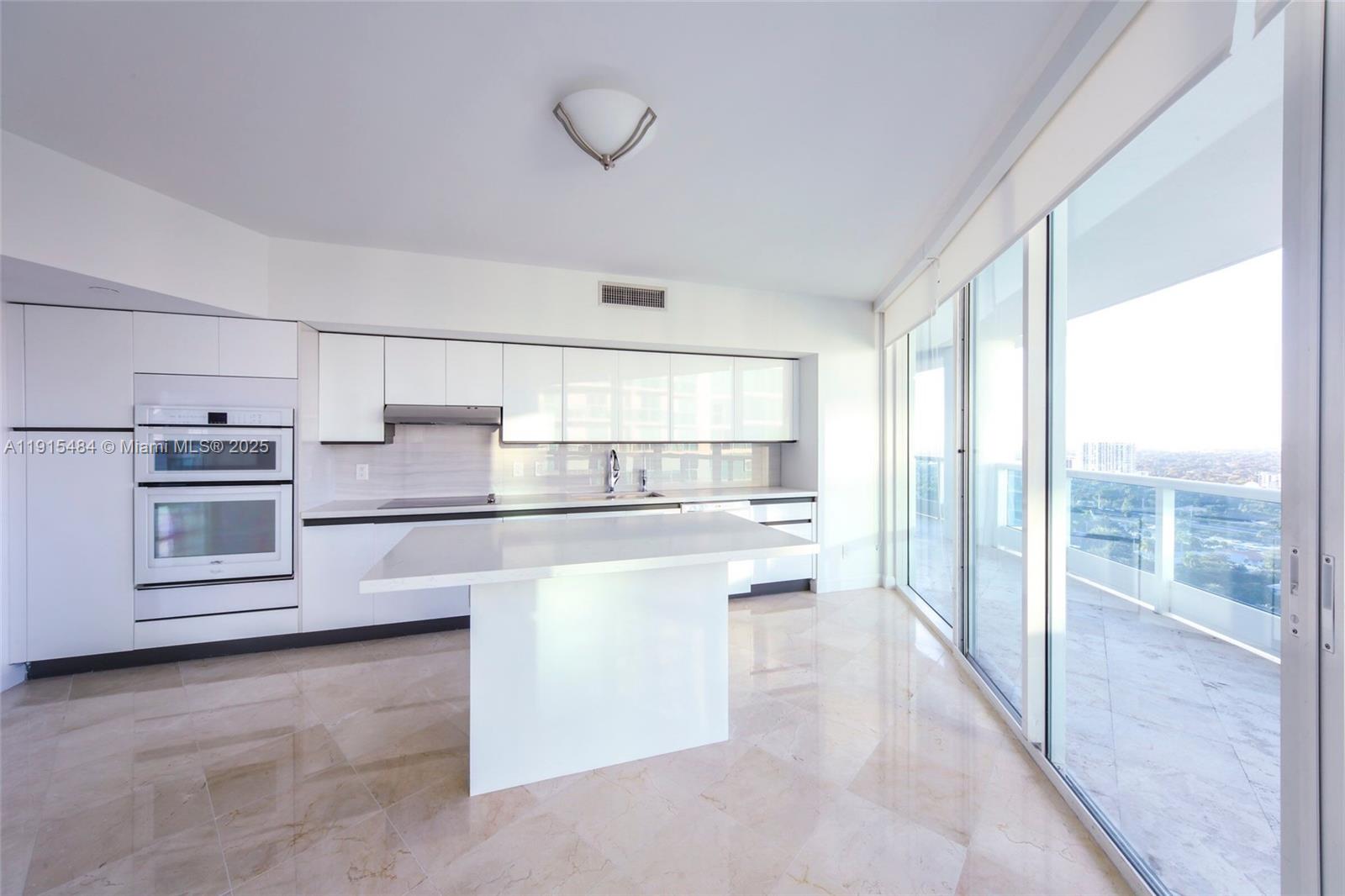 2127 Brickell Avenue, Unit 2504 Miami, FL 33129 - Photo 11 of 41 a kitchen with white cabinets and white appliances