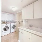 a utility room with sink dryer and washer