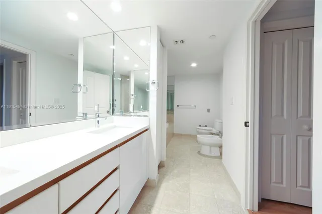 a bathroom with a sink and mirror with toilet