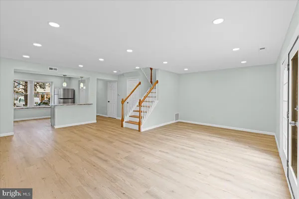a view of an empty room with wooden floor