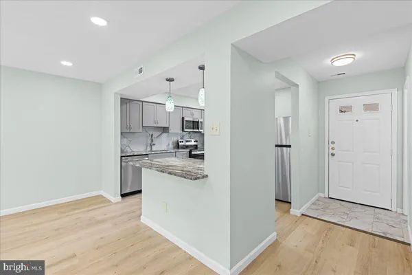 a kitchen with stainless steel appliances granite countertop a refrigerator and a sink