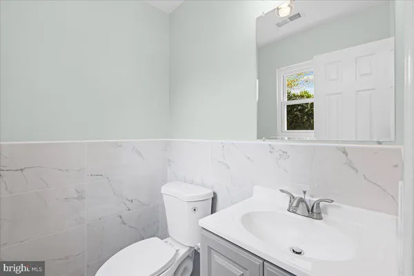 a bathroom with a sink mirror and toilet