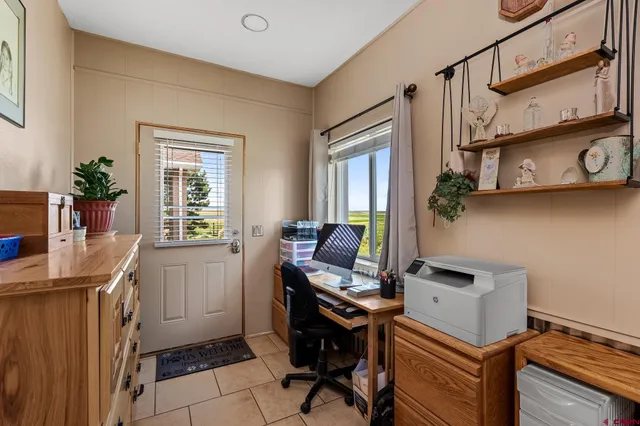 a view of a workspace with furniture and a window