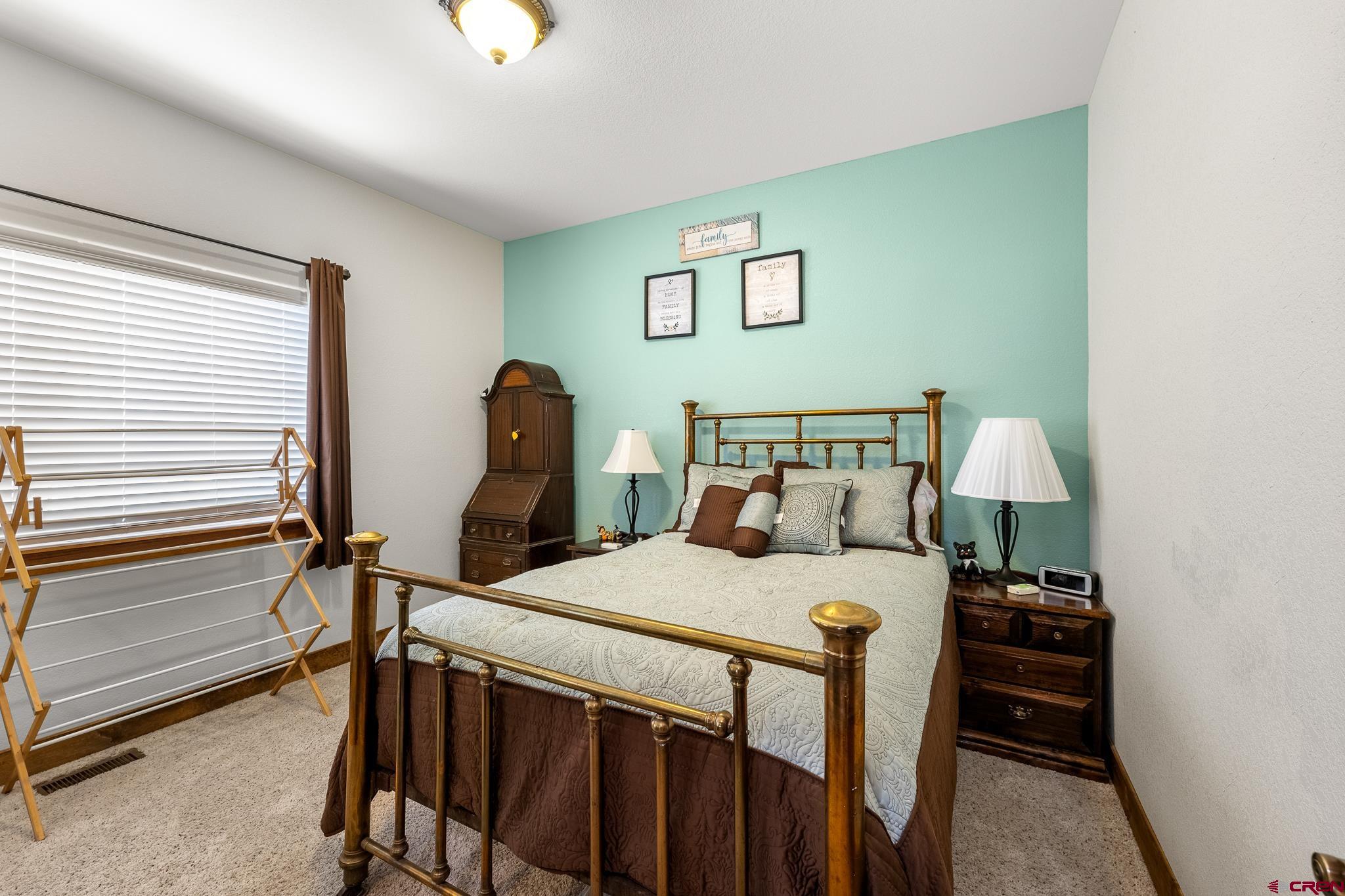 13723 Rd T Cahone, CO 81320 - Photo 19 of 36 a bedroom with a bed and a chandelier