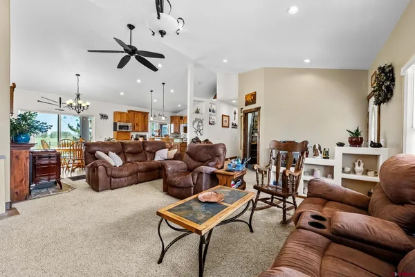 a living room with furniture kitchen view and a wooden floor