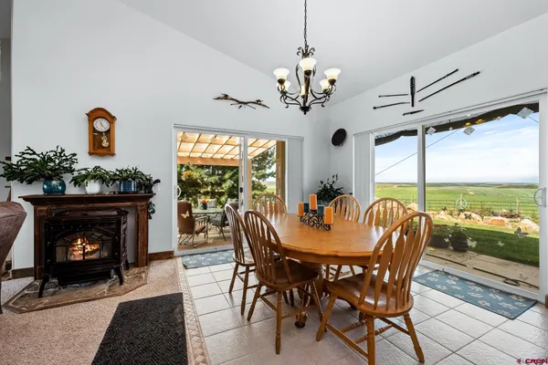 a dining room with furniture a fireplace and large windows
