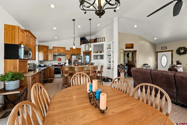 a living room with furniture kitchen view and a chandelier