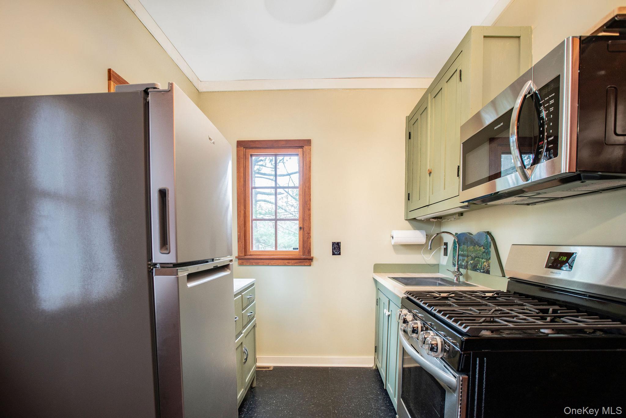 11 Locust Drive Cold Spring, NY 10516 - Photo 9 of 20 Kitchen with gas stove and microwave, leading to back yard.