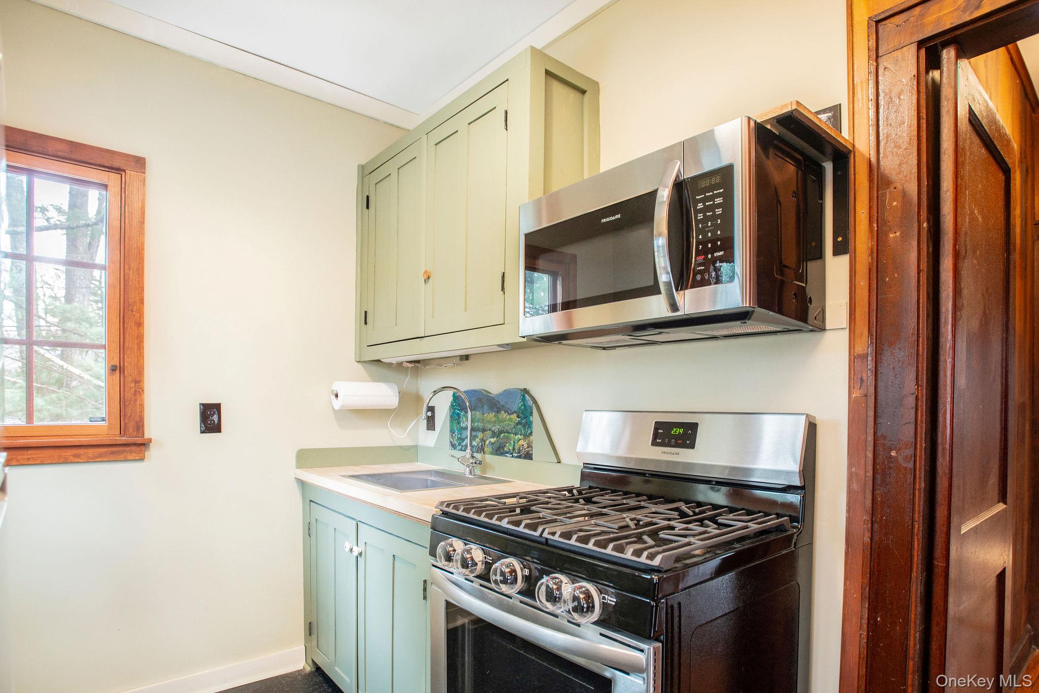 11 Locust Drive Cold Spring, NY 10516 - Photo 10 of 20 Kitchen with gas stove and microwave, leading to back yard.