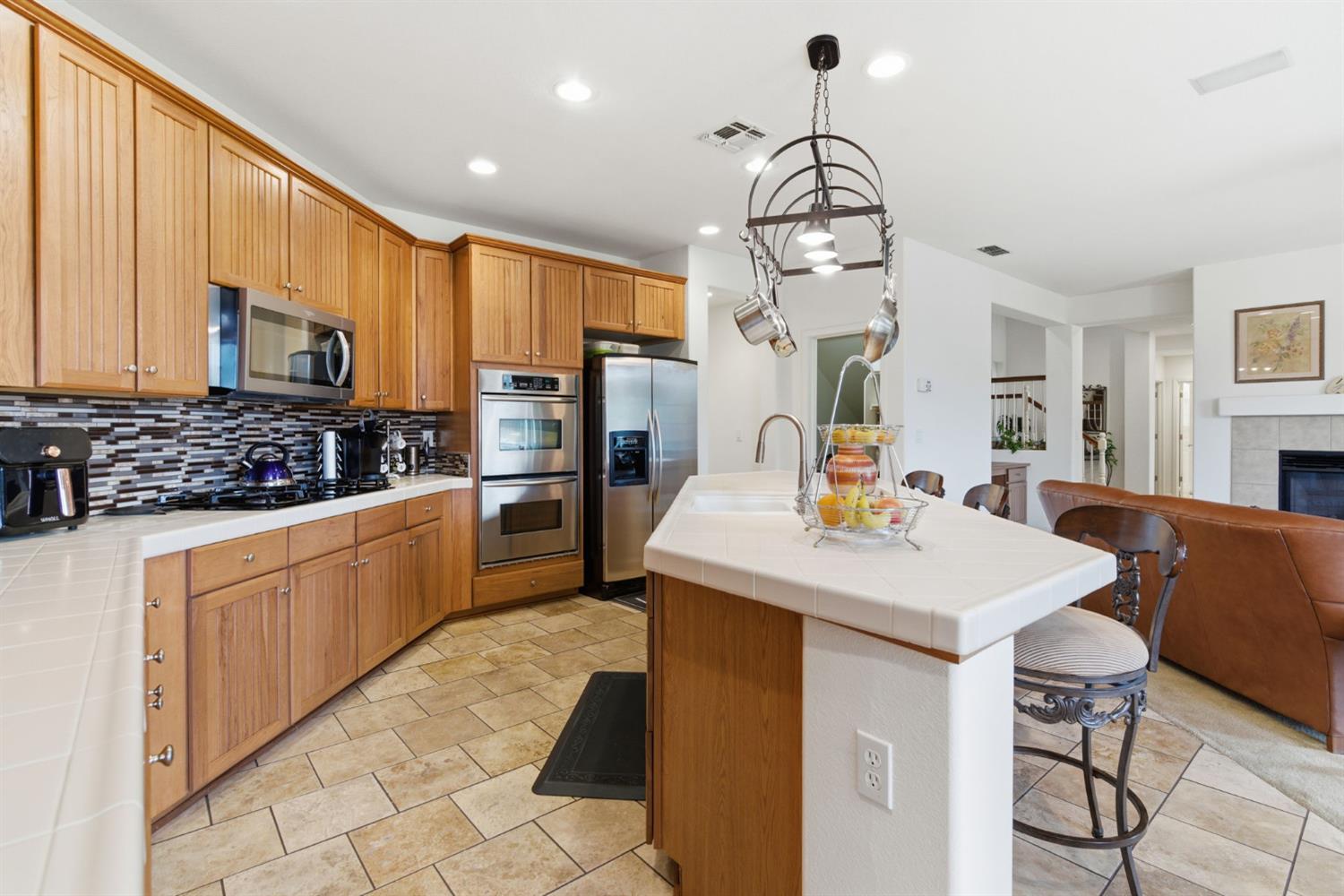 1806 West Ripon Road Ripon, CA 95366 - Photo 21 of 65 a kitchen with stainless steel appliances kitchen island granite countertop a sink a microwave cabinets and chairs
