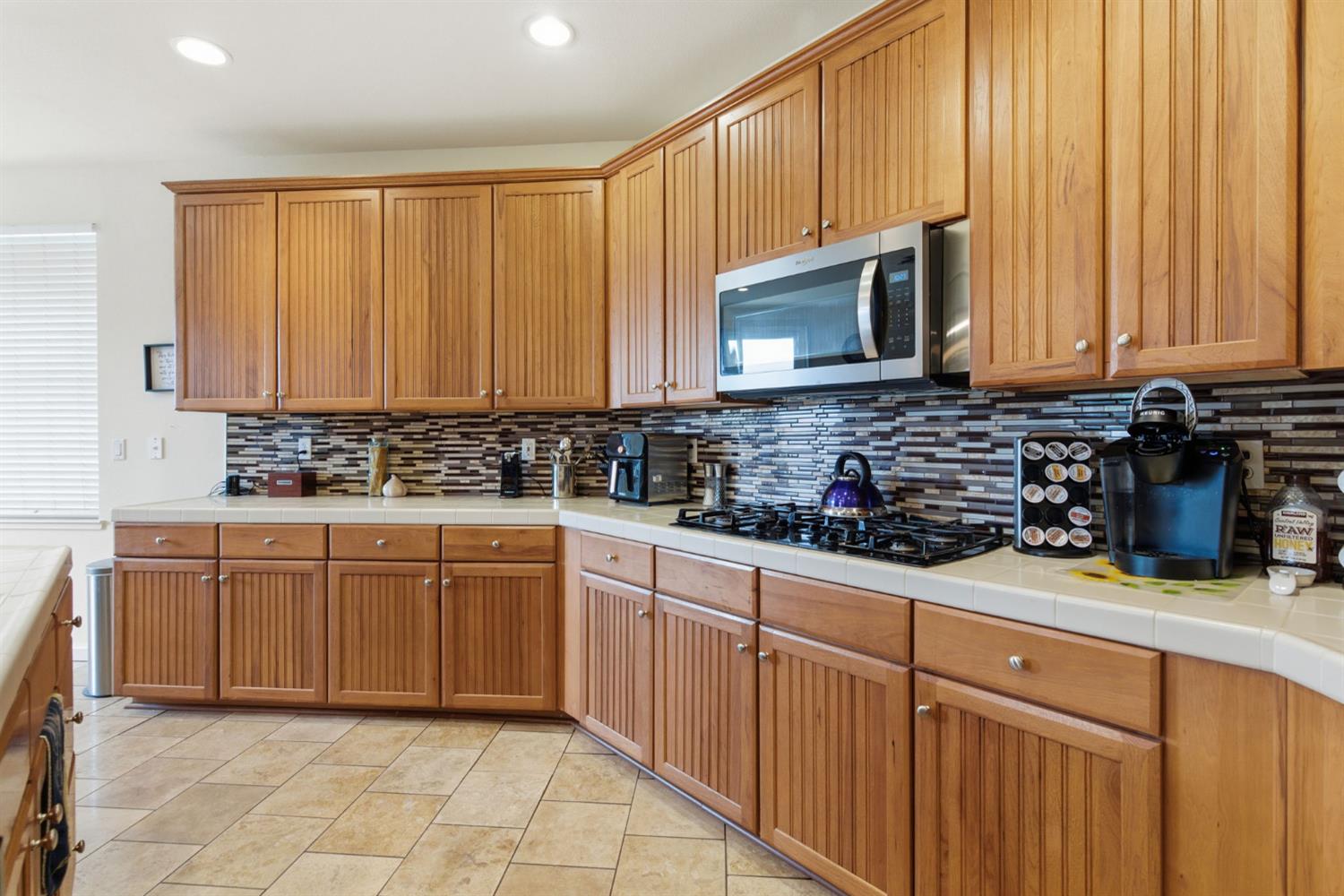 1806 West Ripon Road Ripon, CA 95366 - Photo 23 of 65 a kitchen with stainless steel appliances granite countertop a stove a sink a microwave and cabinets