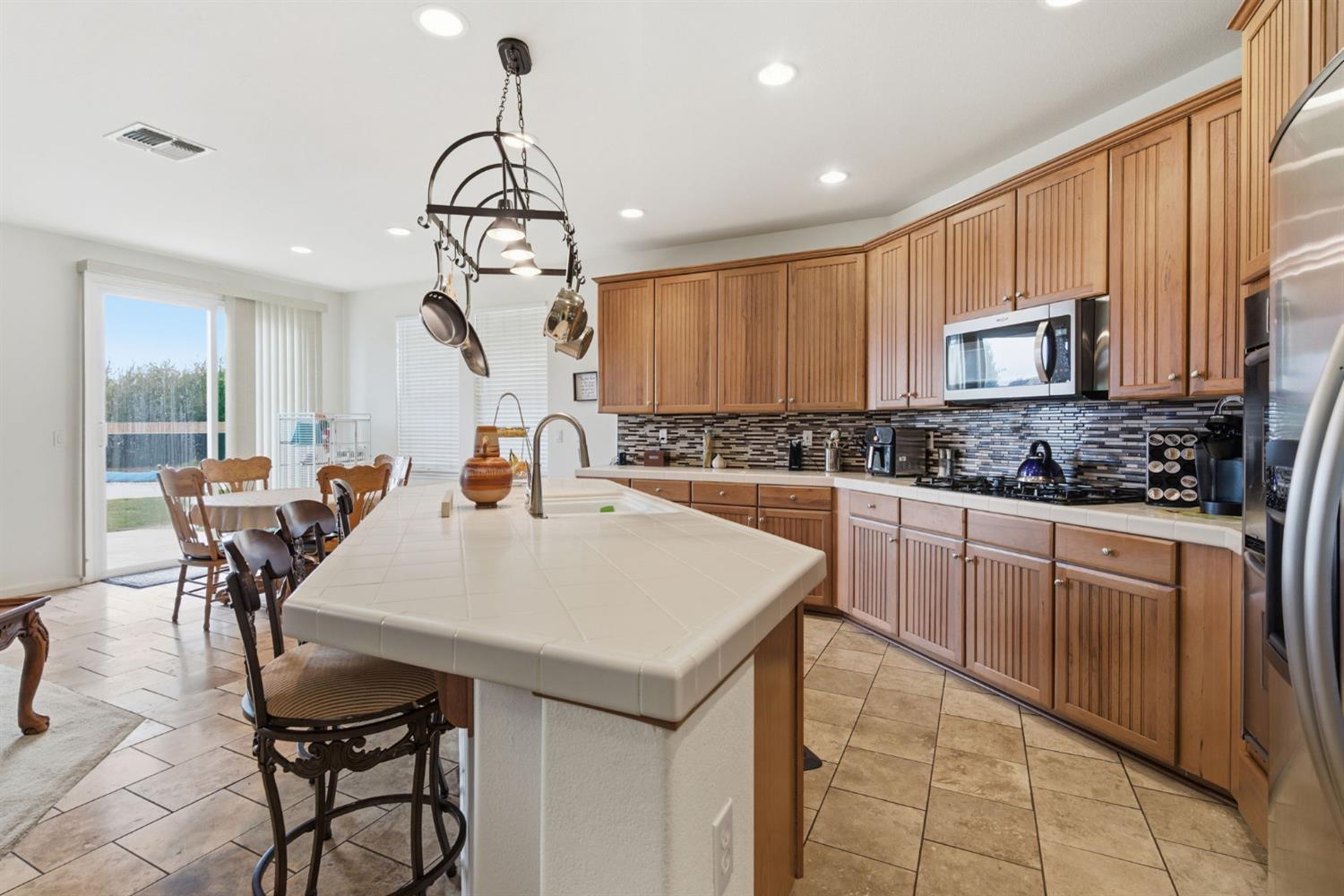 1806 West Ripon Road Ripon, CA 95366 - Photo 24 of 65 a kitchen with a table chairs stove and cabinets