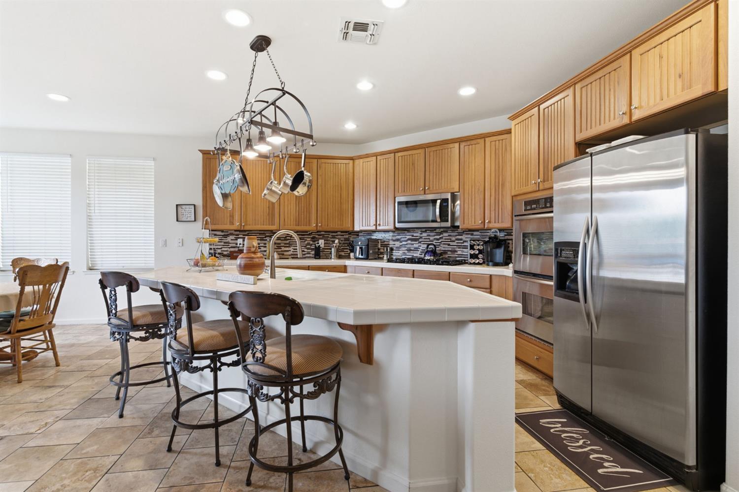 1806 West Ripon Road Ripon, CA 95366 - Photo 26 of 65 a kitchen with stainless steel appliances granite countertop a sink a stove a refrigerator cabinets and chairs