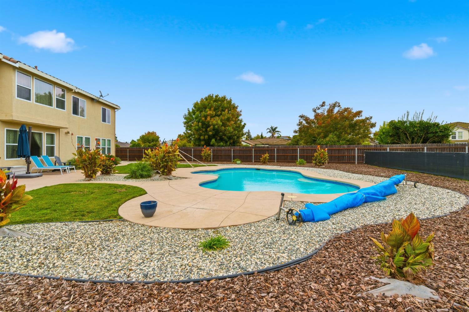 1806 West Ripon Road Ripon, CA 95366 - Photo 46 of 65 a view of a swimming pool with a bench and trees in the background