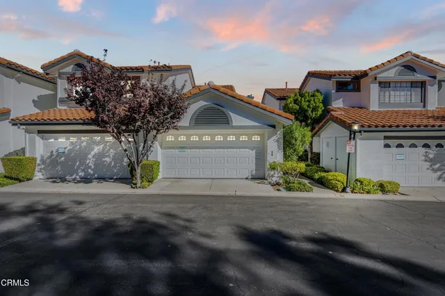 a front view of a house with a garden and parking space