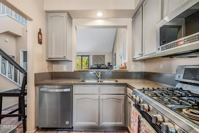 a kitchen with kitchen island granite countertop a sink stainless steel appliances and cabinets