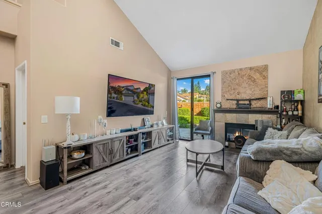 a living room with furniture a fireplace and a flat screen tv