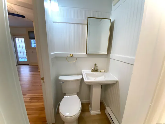 a bathroom with a toilet sink and mirror