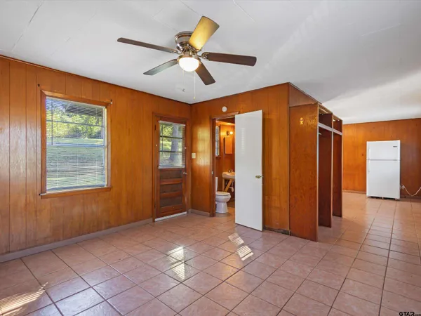 an empty room with fan and windows