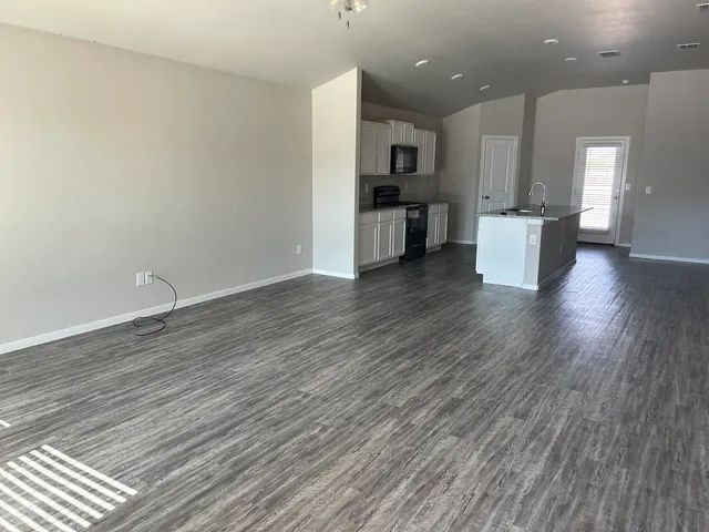 a view of a kitchen with wooden floor and a sink