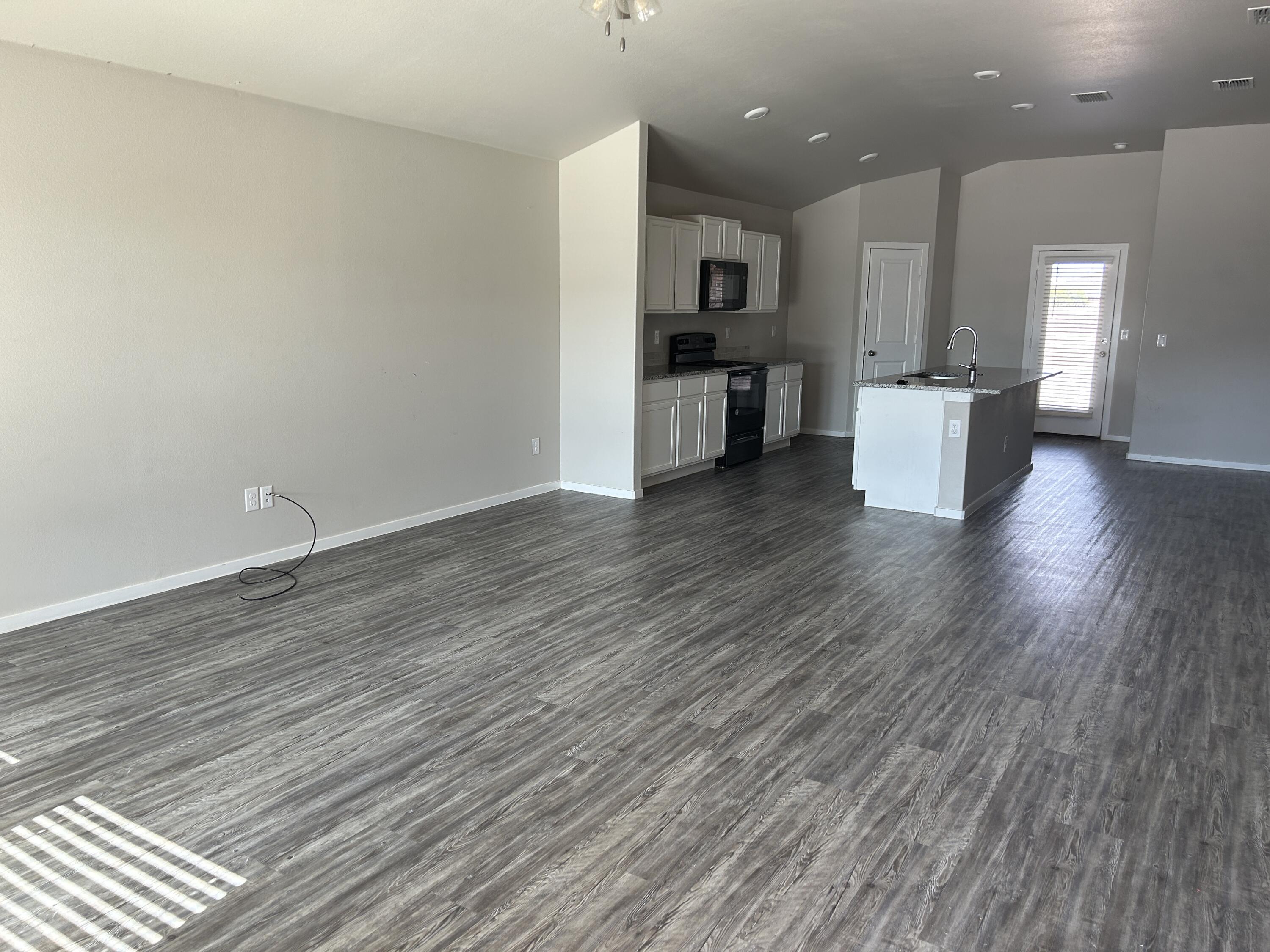 2122 North Texas Avenue Lubbock, TX 79403 - Photo 2 of 7 a view of a kitchen with wooden floor and a sink