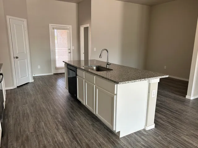 a kitchen with sink a wooden floor and white doors