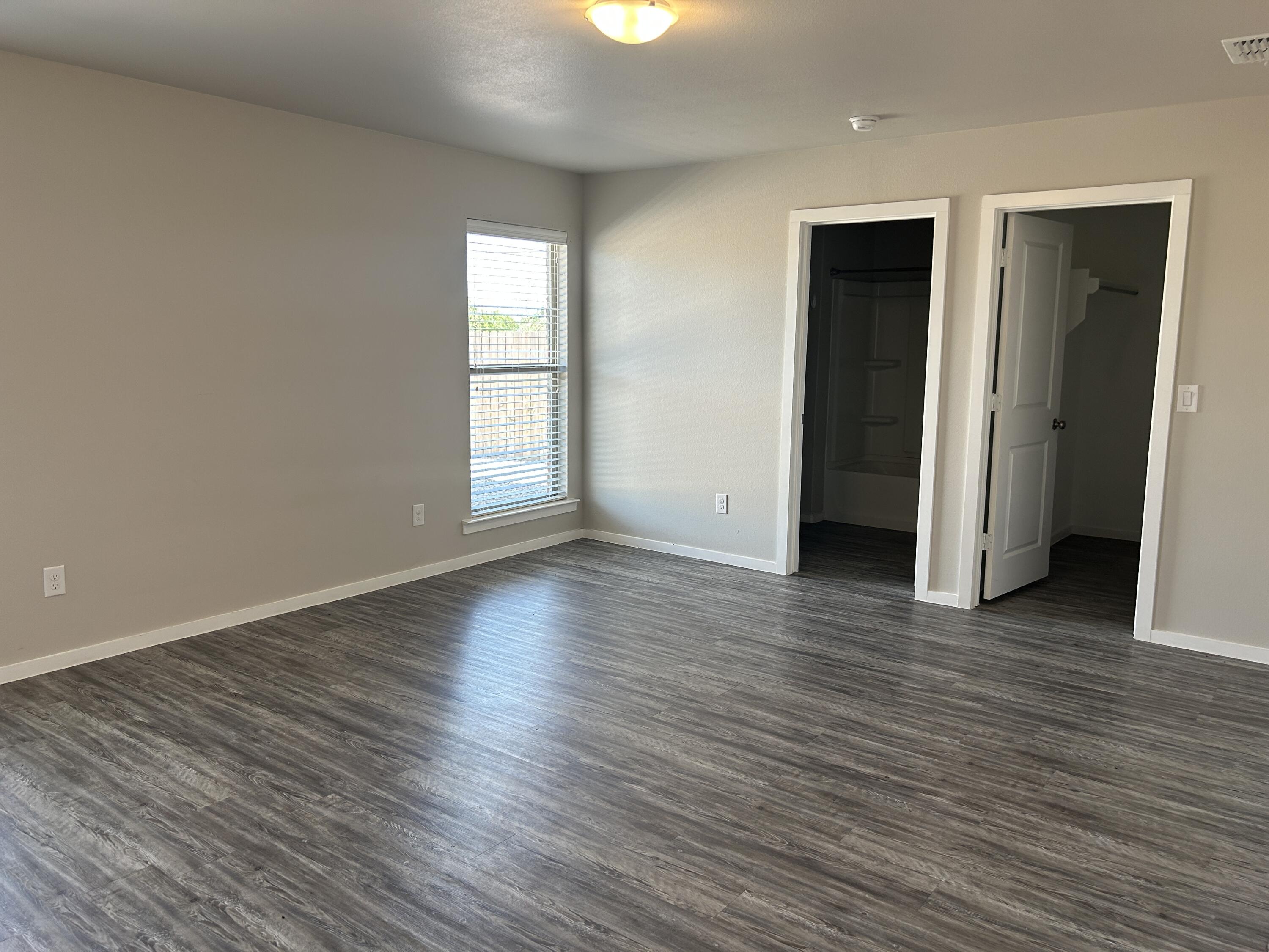2122 North Texas Avenue Lubbock, TX 79403 - Photo 6 of 7 an empty room with wooden floor and windows