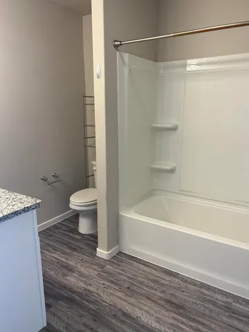 a bathroom with a shower a bathtub and a toilet
