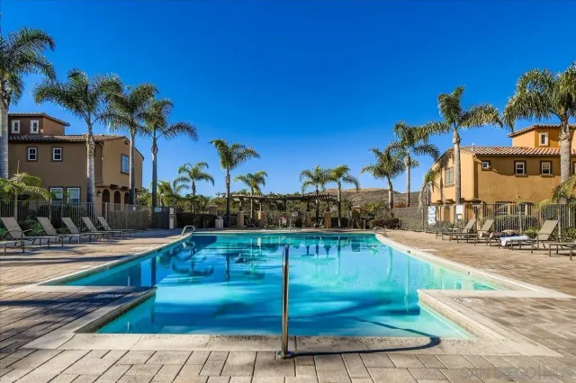 a swimming pool with outdoor seating and a potted plant