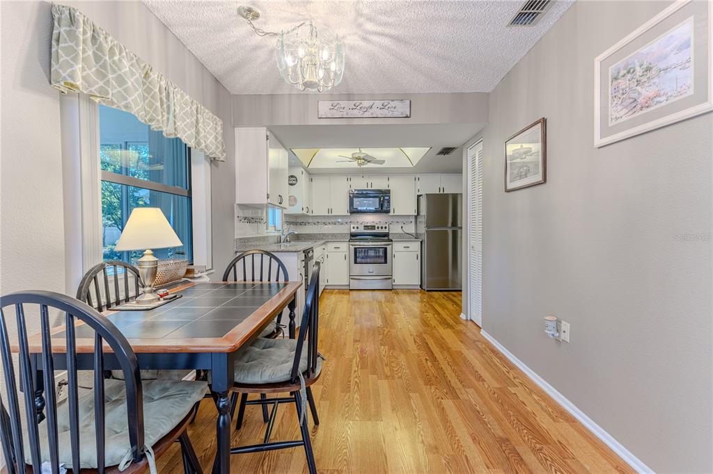 6375 Ocean Pines Lane Spring Hill, FL 34606 - Photo 14 of 50 a dining room with furniture a chandelier and wooden floor