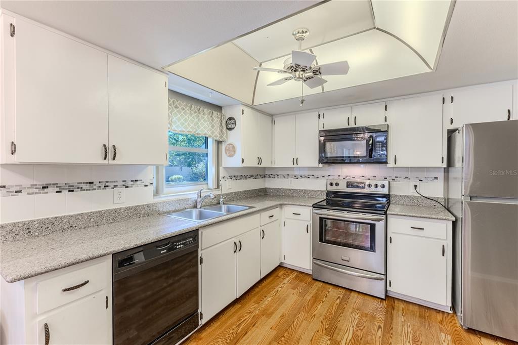 6375 Ocean Pines Lane Spring Hill, FL 34606 - Photo 15 of 50 a kitchen with kitchen island granite countertop a sink cabinets stainless steel appliances and a counter space