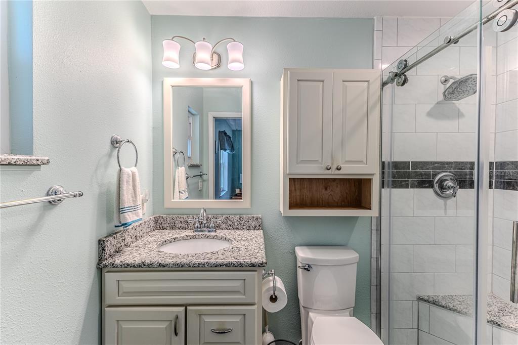 6375 Ocean Pines Lane Spring Hill, FL 34606 - Photo 22 of 50 a bathroom with a granite countertop sink a toilet and a shower