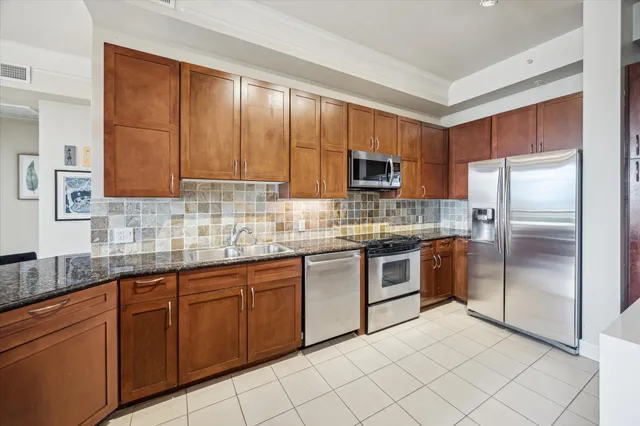 a kitchen with stainless steel appliances granite countertop a stove a sink and a microwave