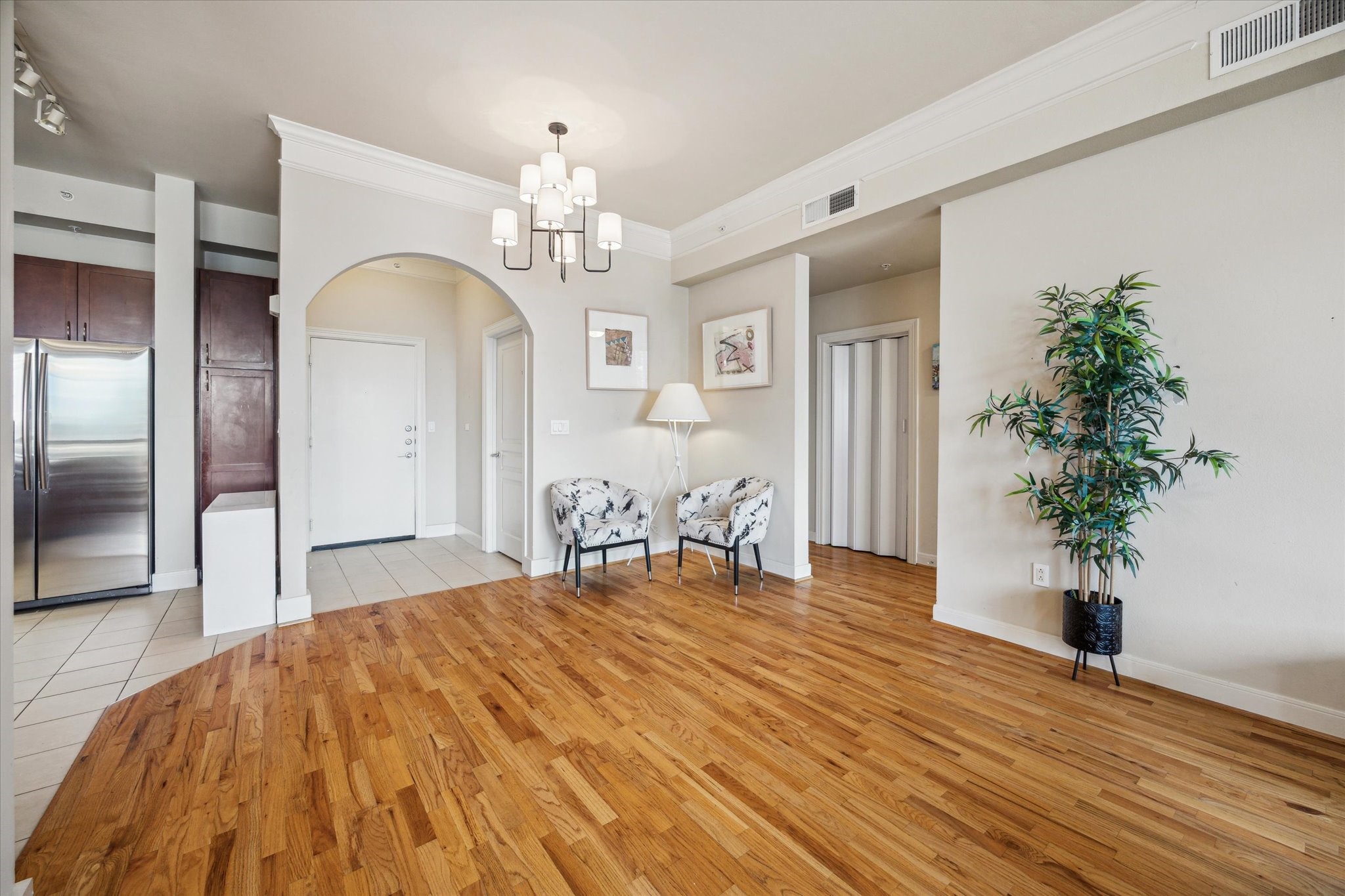 3333 Allen Parkway, Unit 1004 Houston, TX 77019 - Photo 10 of 36 a large room with chandelier fan and wooden floor