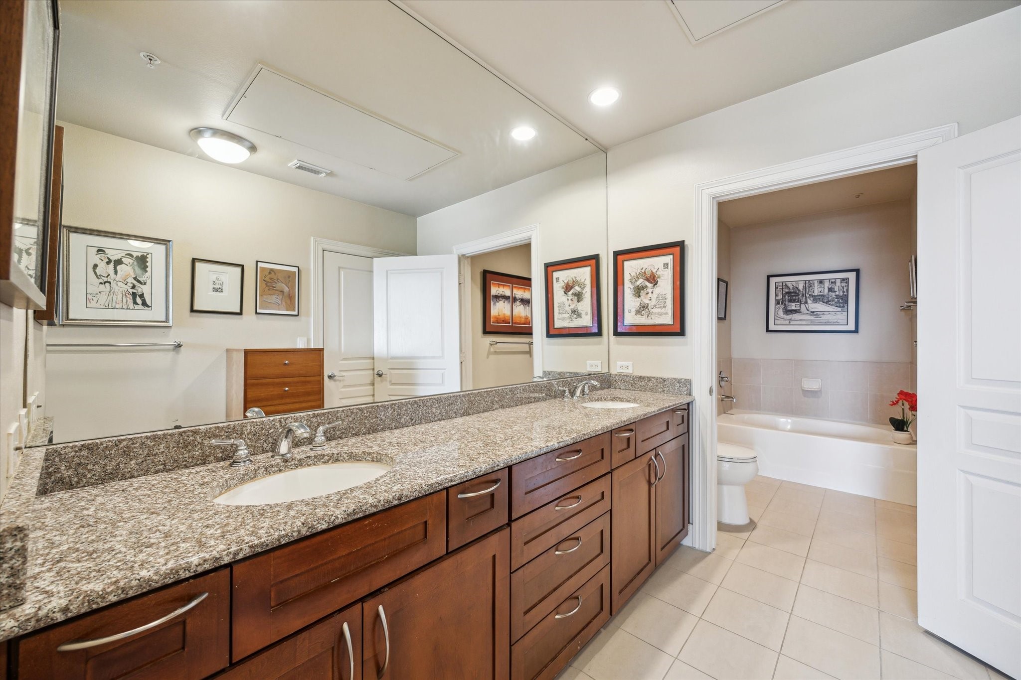 3333 Allen Parkway, Unit 1004 Houston, TX 77019 - Photo 15 of 36 a bathroom with a granite countertop double vanity sink a mirror and a bathtub