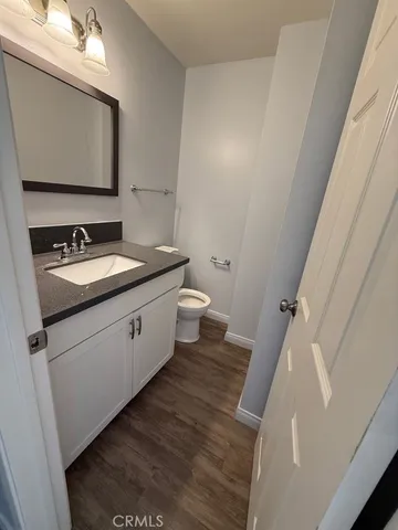 a bathroom with a granite countertop sink toilet and mirror