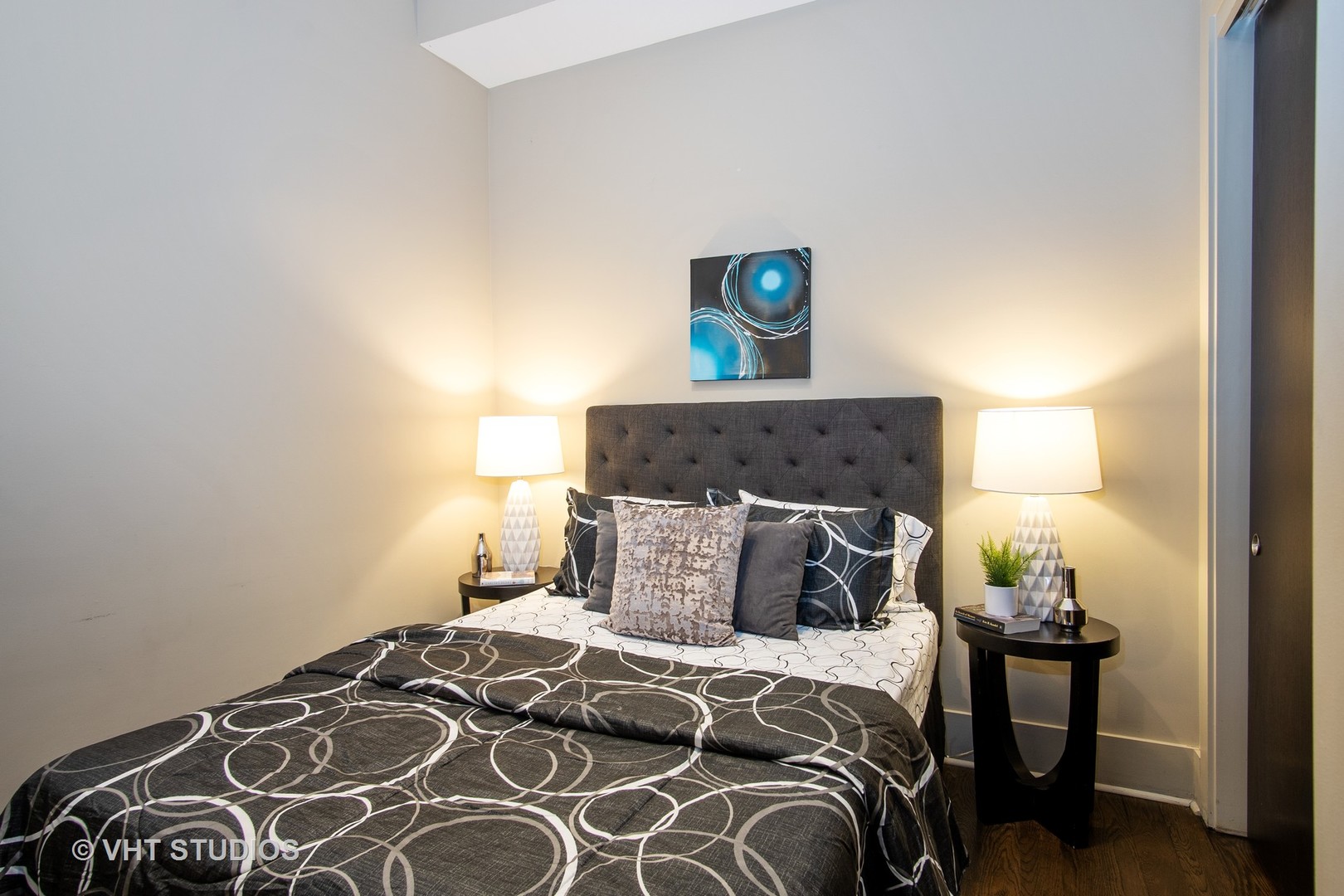 1735 West Erie Street, Unit 1N Chicago, IL 60622 - Photo 14 of 18 a bedroom with a bed and a lamp on dresser