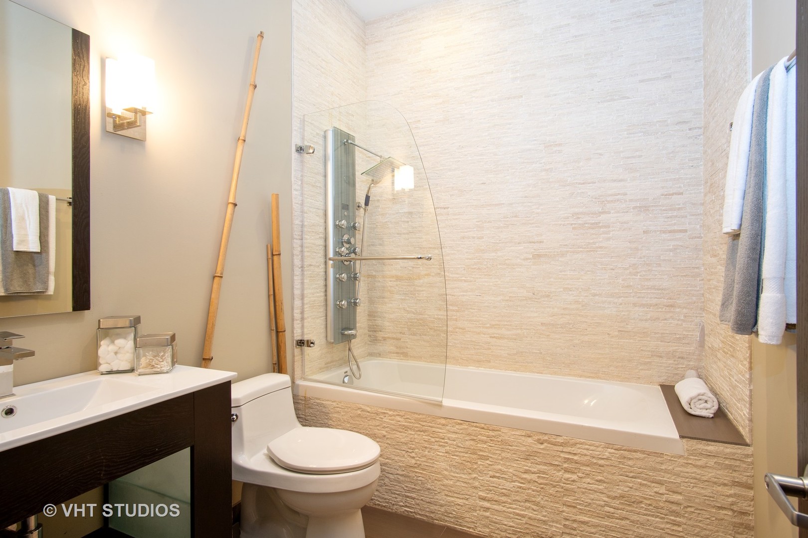 1735 West Erie Street, Unit 1N Chicago, IL 60622 - Photo 15 of 18 a bathroom with a granite countertop toilet a sink and bathtub