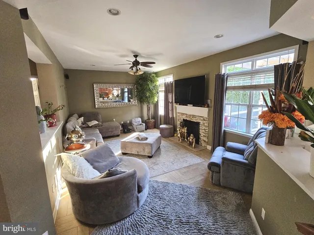 a living room with furniture a flat screen tv and a fireplace