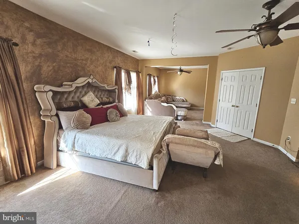 a spacious bedroom with a bed and large windows