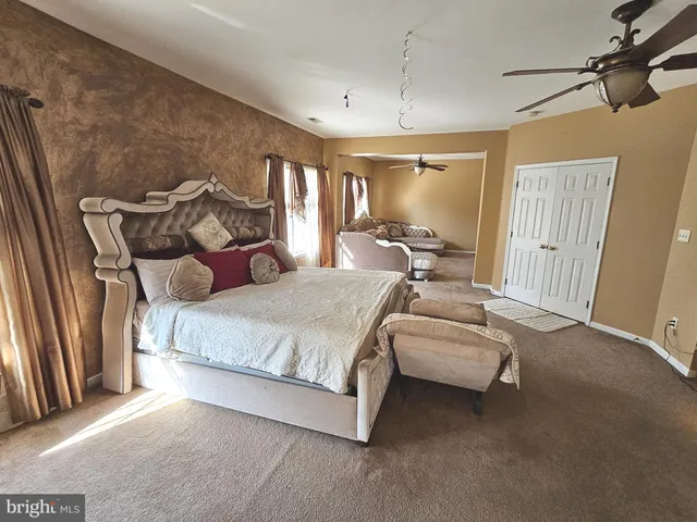 a spacious bedroom with a bed and large windows