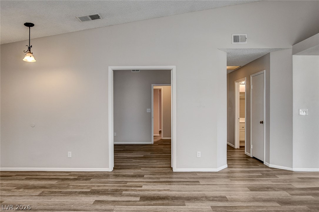 6209 Warm River Road Las Vegas, NV 89108 - Photo 21 of 39 Newly installed wood-look flooring connects various living spaces under vaulted ceilings.
