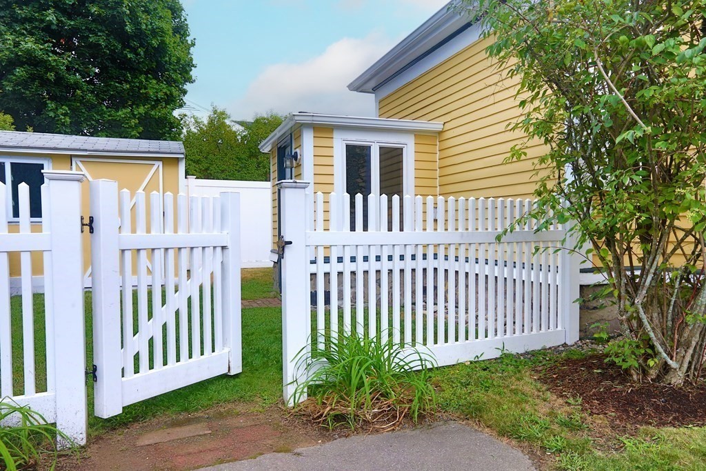 195 Fayette Street Watertown, MA 02472 - Photo 15 of 18 a view of a house with a small yard and wooden fence