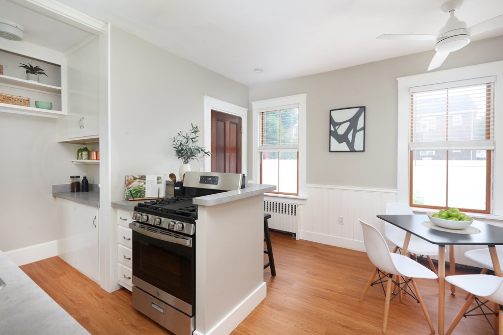 195 Fayette Street Watertown, MA 02472 - Photo 7 of 18 a kitchen with stainless steel appliances kitchen island hardwood floor and stove top oven