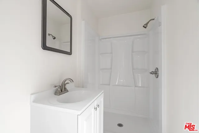 a bathroom with a sink a vanity and shower