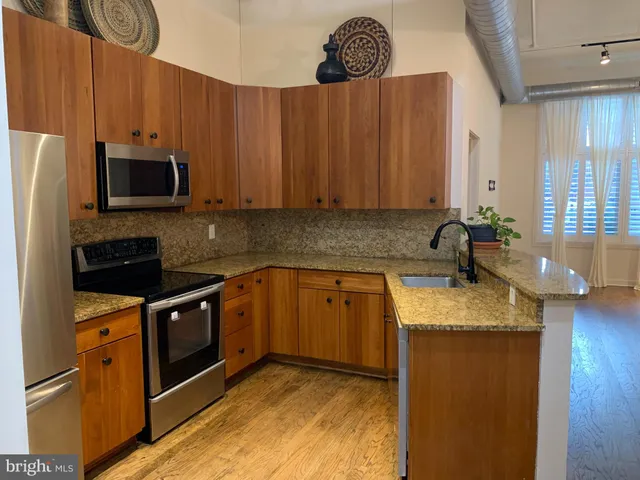 a kitchen with stainless steel appliances a refrigerator and a stove
