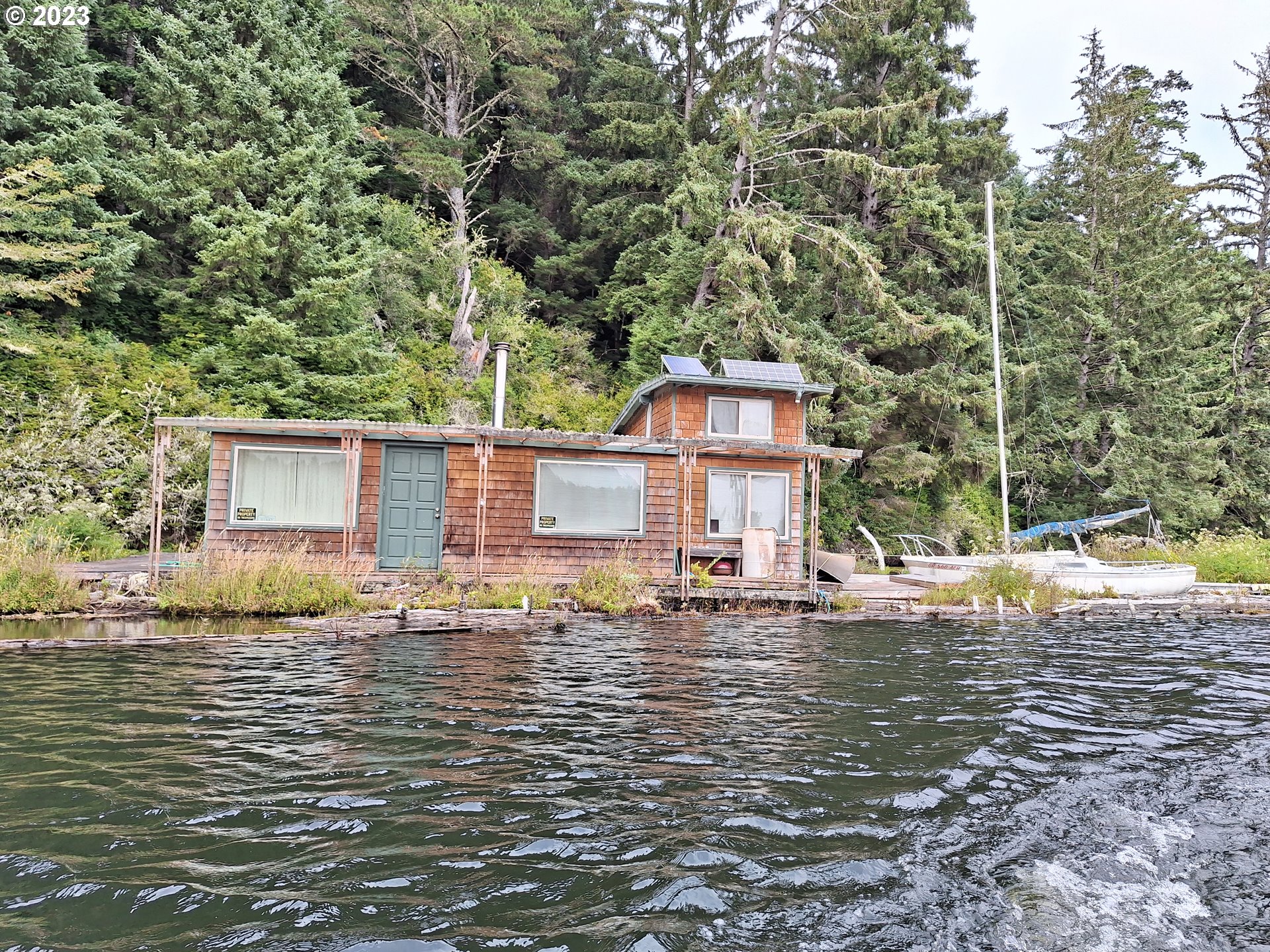 Tahkenitch Gardiner, OR 97441 - Photo 2 of 12 a backyard of a house with large trees and outdoor seating