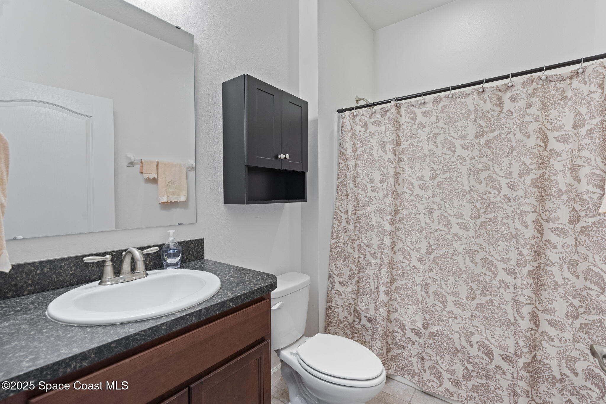 4015 Harvest Circle Rockledge, FL 32955 - Photo 18 of 40 a bathroom with a granite countertop sink toilet a mirror a vanity and shower