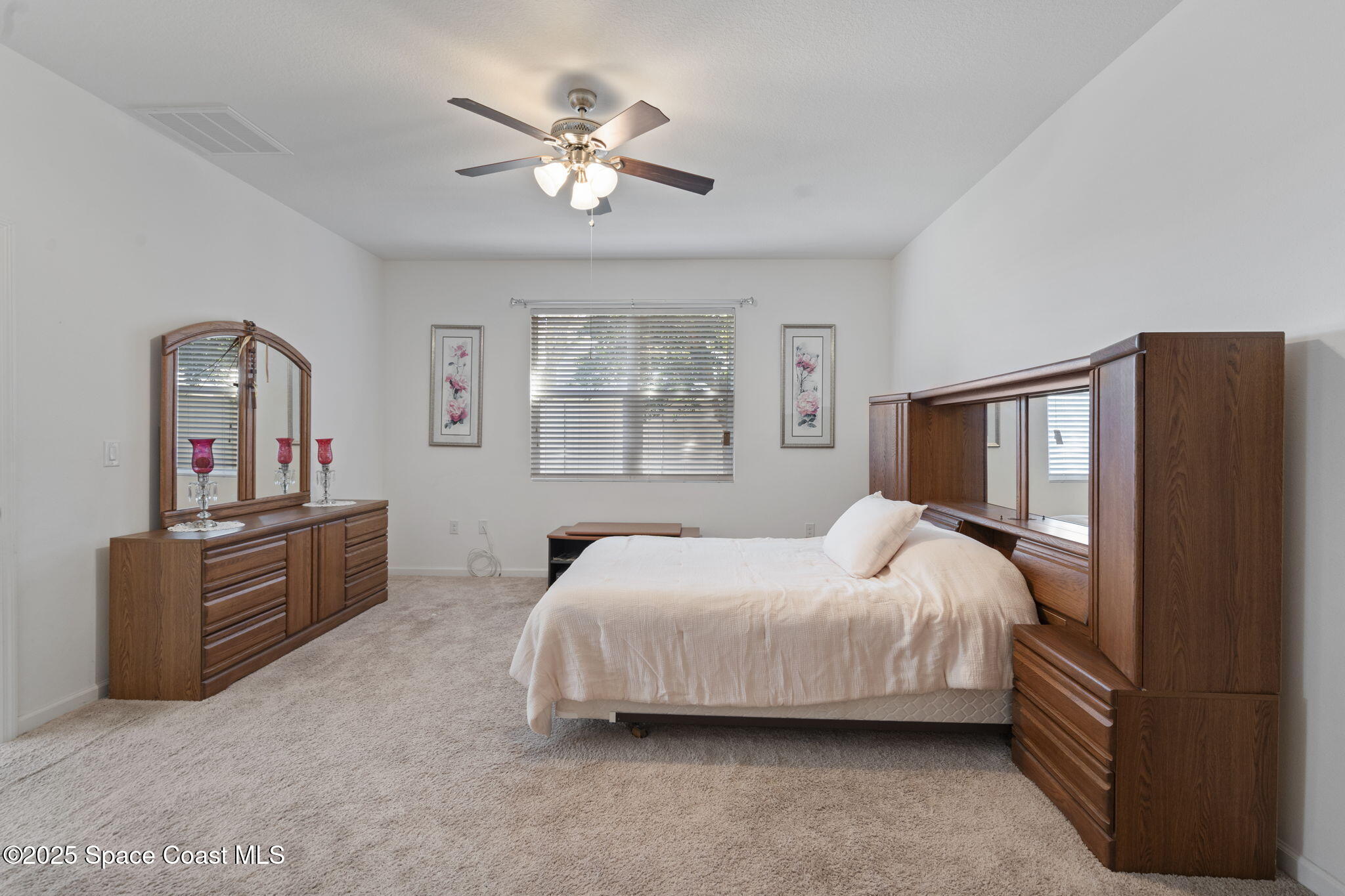 4015 Harvest Circle Rockledge, FL 32955 - Photo 29 of 40 a bedroom with a bed chandelier and dresser